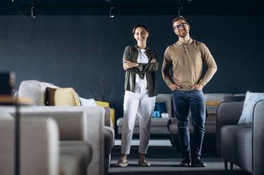 Çift mobilya dükkanında kanepe ve yastık seçiyor.