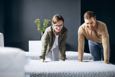 Çift mobilya mağazasında ortipedik yataklı yeni yatak alıyor.