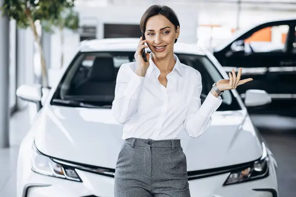 Kadını Araba Galerisinde Arabanın Yanında Telefonla Konuşuyor — Stok fotoğraf