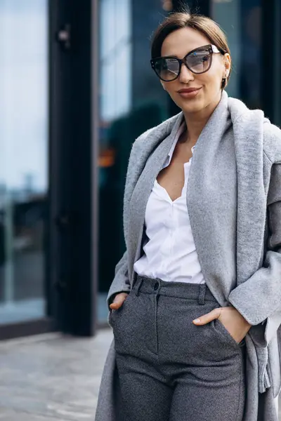 オフィスビル外の灰色のコートの美しいビジネス女性 — ストック写真