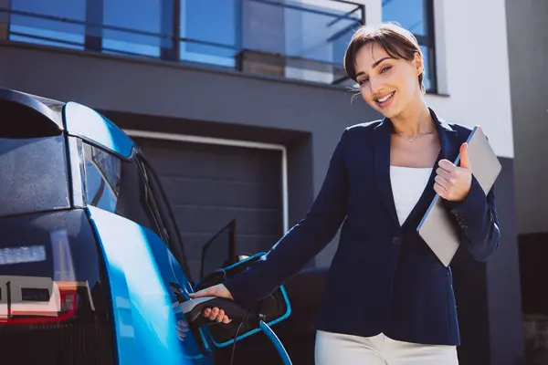 Biznes Kobieta Trzyma Laptopa Przez Jej Samochód Elektryczny — Zdjęcie stockowe