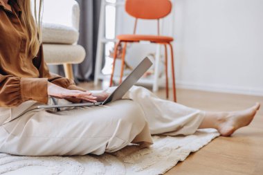 Çalışan genç anne laptopuyla evden çalışıyor.