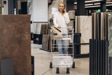 Kabartma malzemeler ve fayans pazarında yürüyen bir kadın