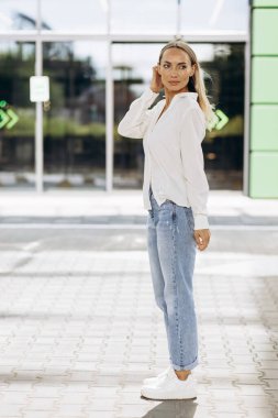 Ofis binasının önünde duran genç kadın.