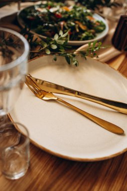 Yemek tabağı, çatal ve bıçaklı şölen masası.
