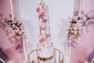 Düğün pastası düğün töreninde çiçeklerle süslenmiş.