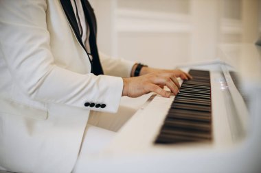 Besteci düğünde piyano çalıyor.