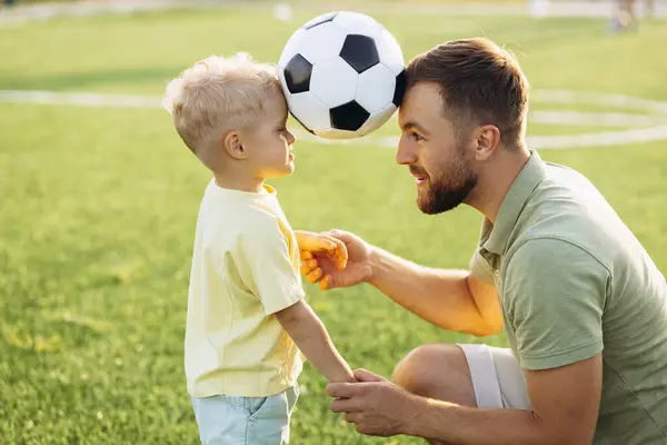 Father with son playing football at the football field