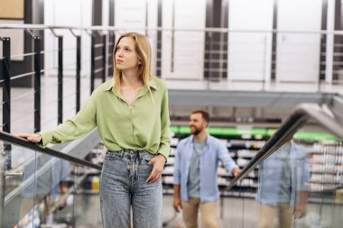 İnşaat malzemeleri pazarındaki yürüyen merdivendeki çift.