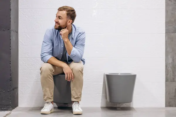 Man sitting on the toilet at the building market