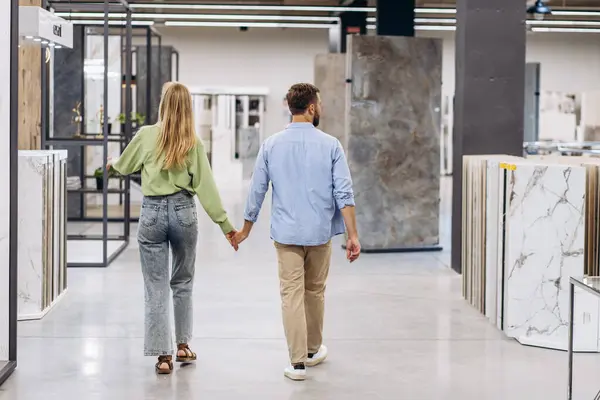 Young couple at the building market choosing tile
