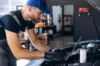 Araba tamircisinin laptopunda araba kontrolü var.