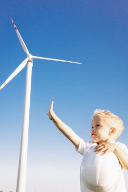 Yel değirmeni türbinlerinin yanında duran miğferli şirin bou.