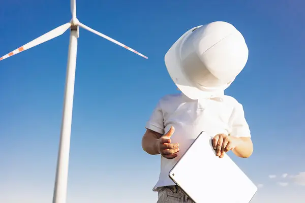 站在风车涡轮机旁边的带头盔的可爱的小傻瓜 — 图库照片