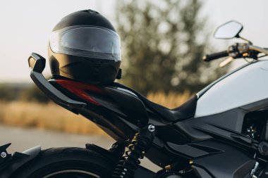 Yolda motosiklette asılı duran kask.