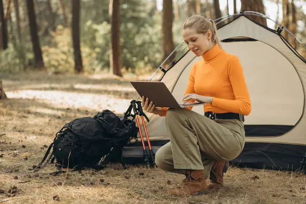 森でラップトップに取り組むテントによる女性 — ストック写真
