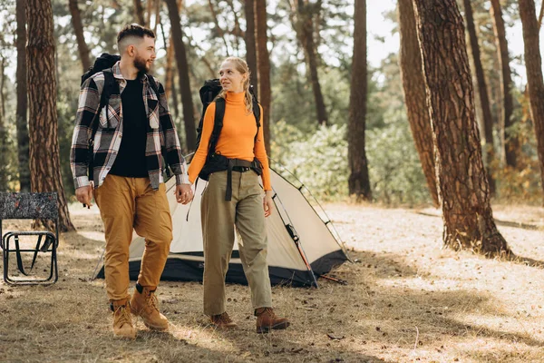 森でバッグと一緒に歩くカップル旅行者 — ストック写真