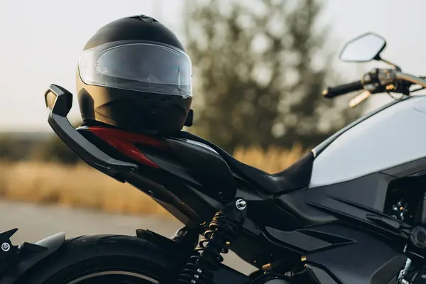头盔挂在公路上的摩托车上 — 图库照片
