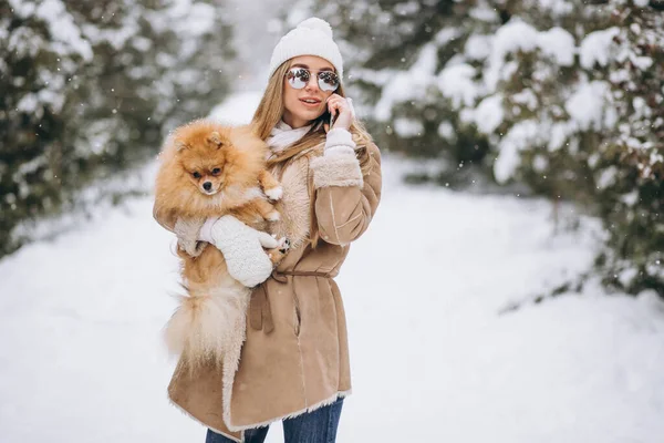 Woman with dog and phone in winter