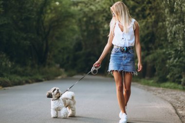 Parkta köpeğiyle güzel bir kadın.