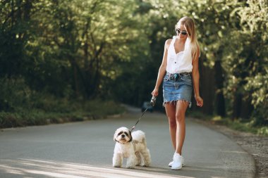 Parkta köpeğiyle güzel bir kadın.