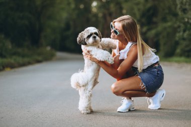 Parkta köpeğiyle güzel bir kadın.