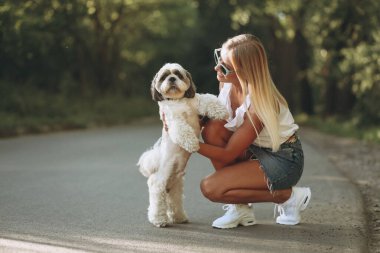 Parkta köpeğiyle güzel bir kadın.