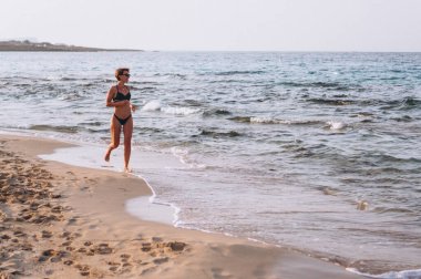 Deniz kıyısında koşan bir kadın