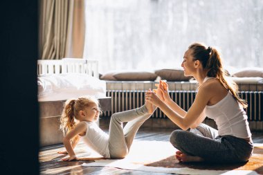 Mother and daughter yoga at home