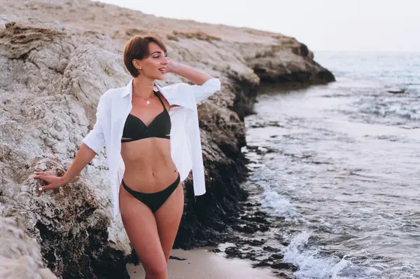 Beautiful woman in bikini posing by the ocean