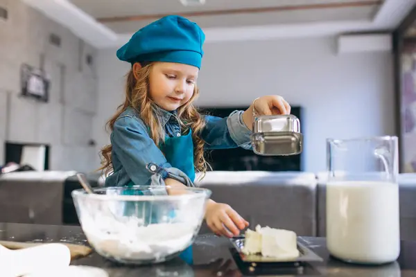 Little cute girl baking in the kitchen