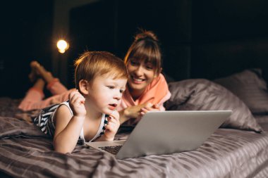 Anne ve oğlu bilgisayarda çalışıyor.