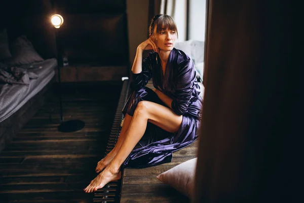 ベッドルームの紫色のバスローブの女性 — ストック写真