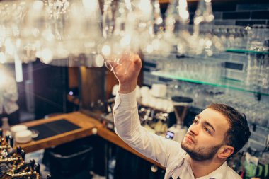 Tezgahta içki ve kokteyl yapan yakışıklı bir barmen.