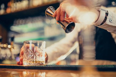 Tezgahta içki ve kokteyl yapan yakışıklı bir barmen.