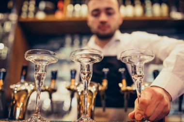 Tezgahta içki ve kokteyl yapan yakışıklı bir barmen.