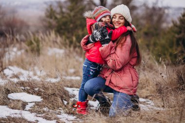 Mother with little daughter in a winter forest