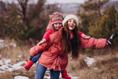 Mother with little daughter in a winter forest