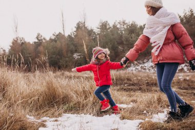 Mother with little daughter in a winter forest