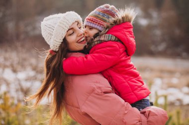 Mother with little daughter in a winter forest