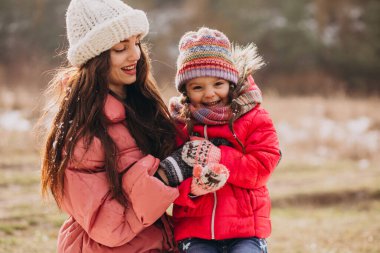 Mother with little daughter in a winter forest