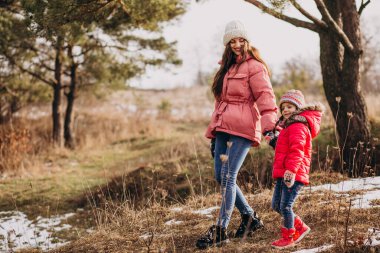 Mother with little daughter in a winter forest