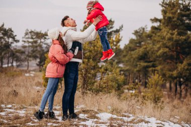 Genç aile kışın ormanda birlikte yürür.