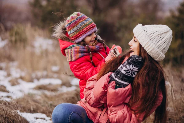 Mother with little daughter in a winter forest