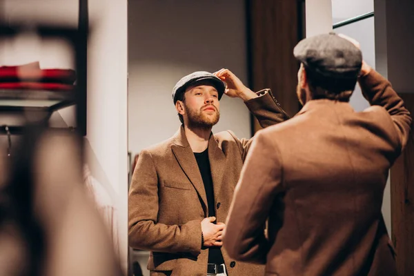 Νεαρός Όμορφος Άντρας Διαλέγει Καπέλο Στο Μαγαζί — Φωτογραφία Αρχείου