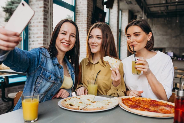 Girls friends having pizza at a bar at a lunch time