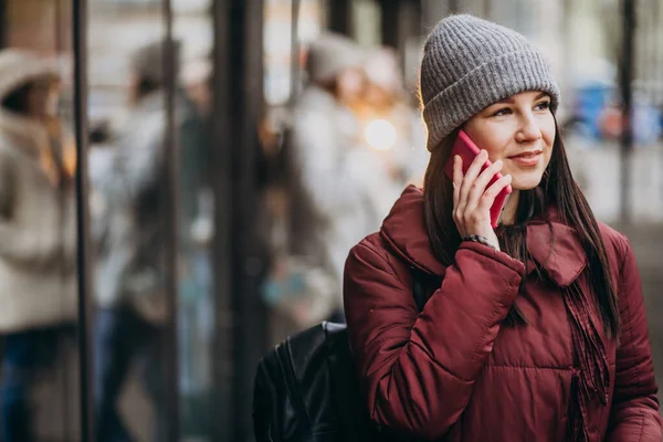 Girl using phone outside the street and meeting with friends
