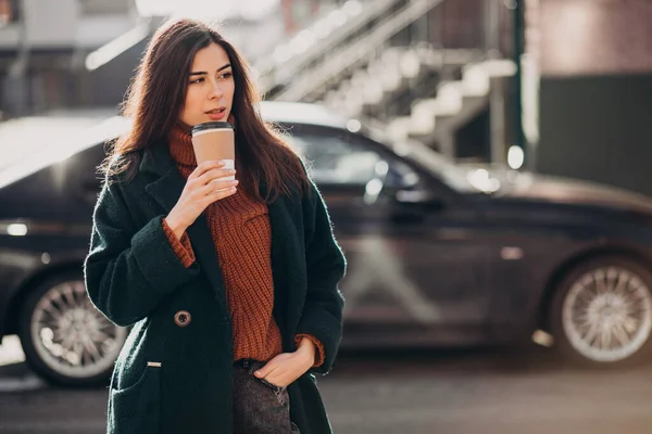 車でコーヒーを飲んでいる若い女性 — ストック写真