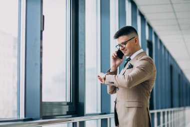 Ofiste telefonu olan yakışıklı bir iş adamı.