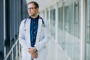 Klinikte steteskobu olan yakışıklı genç bir doktor.